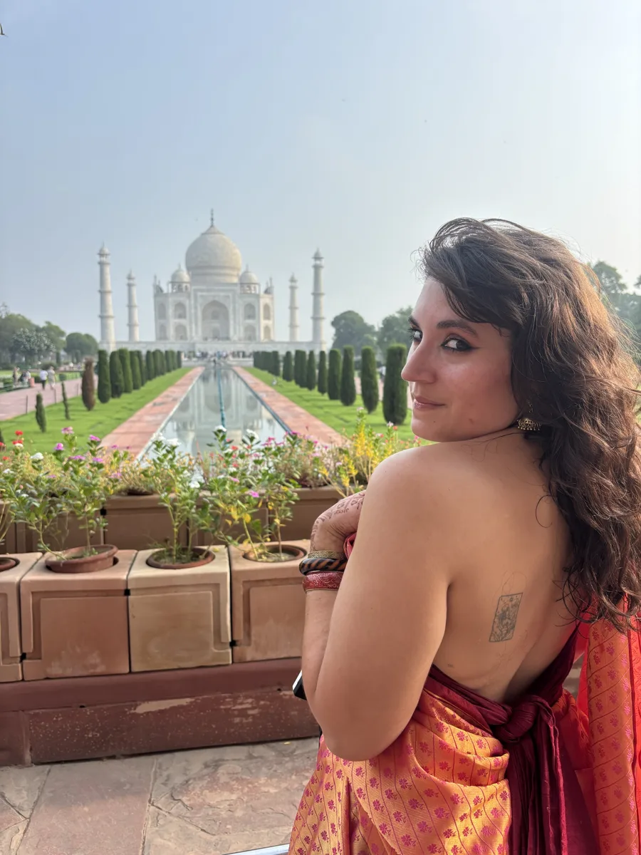 Traveler in a sari looking back at the Taj Mahal